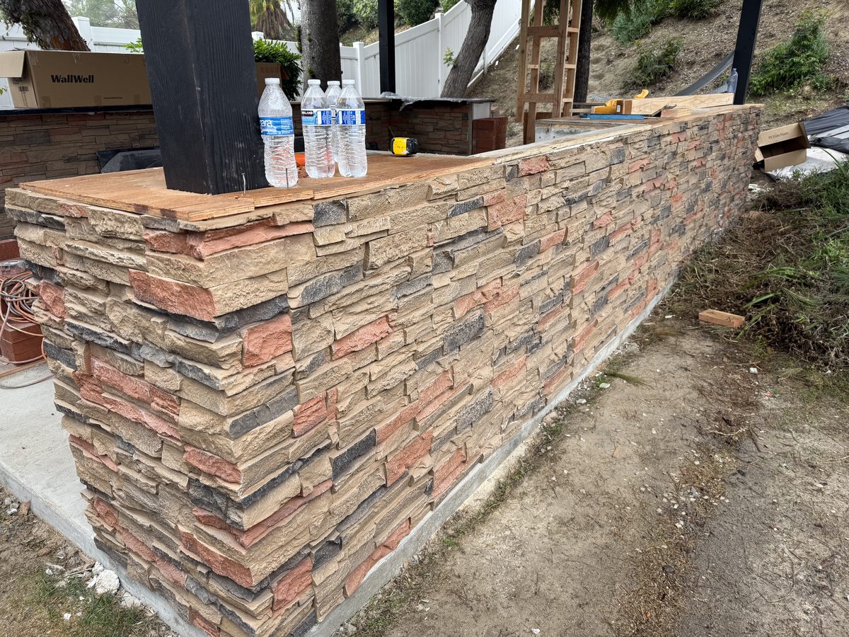DIY outdoor kitchen wall with WallWell Sienna Dawn stacked stone panels