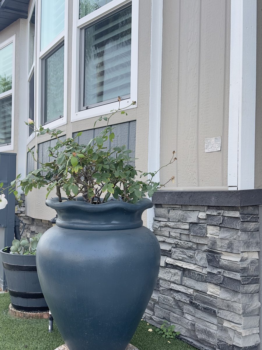 FogStone stacked stone wainscot under window with planter