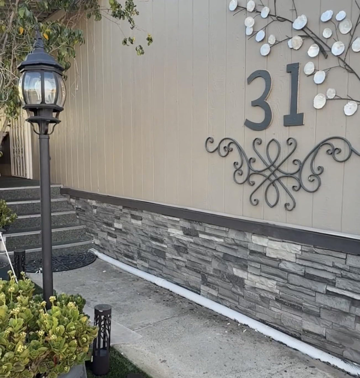 WallWell FogStone faux stone sample piece held against a wall